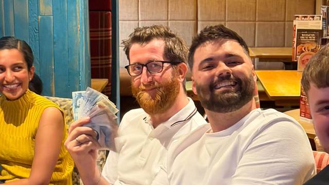 Two smiling quiz winners at Teal Farm, one holding up their winnings