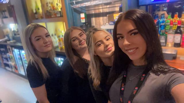 A selfie of four smiling Teal Farm bar staff